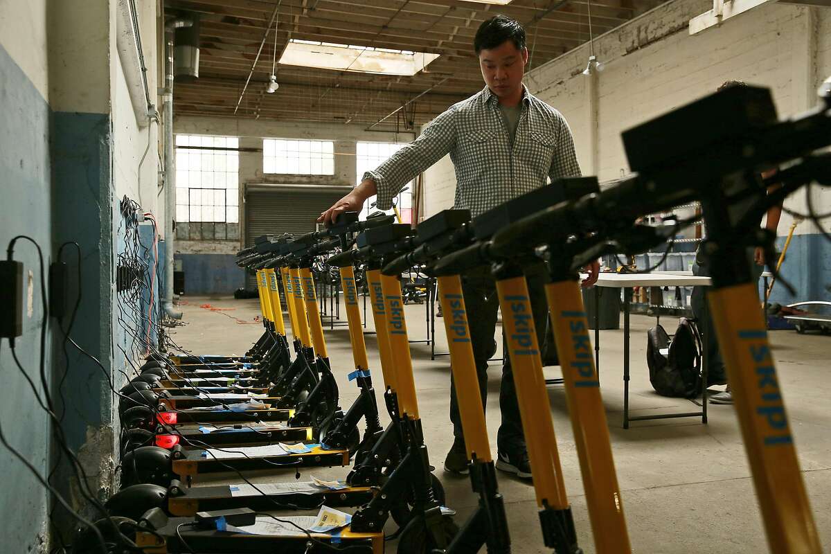 Skip co-founder Matthew Tran checks his scooters, Friday, June 15, 2018, in San Francisco, Calif. Skip, a scooter rental, is one of 12 companies applying for a permit to have an e-scooter program in the city.