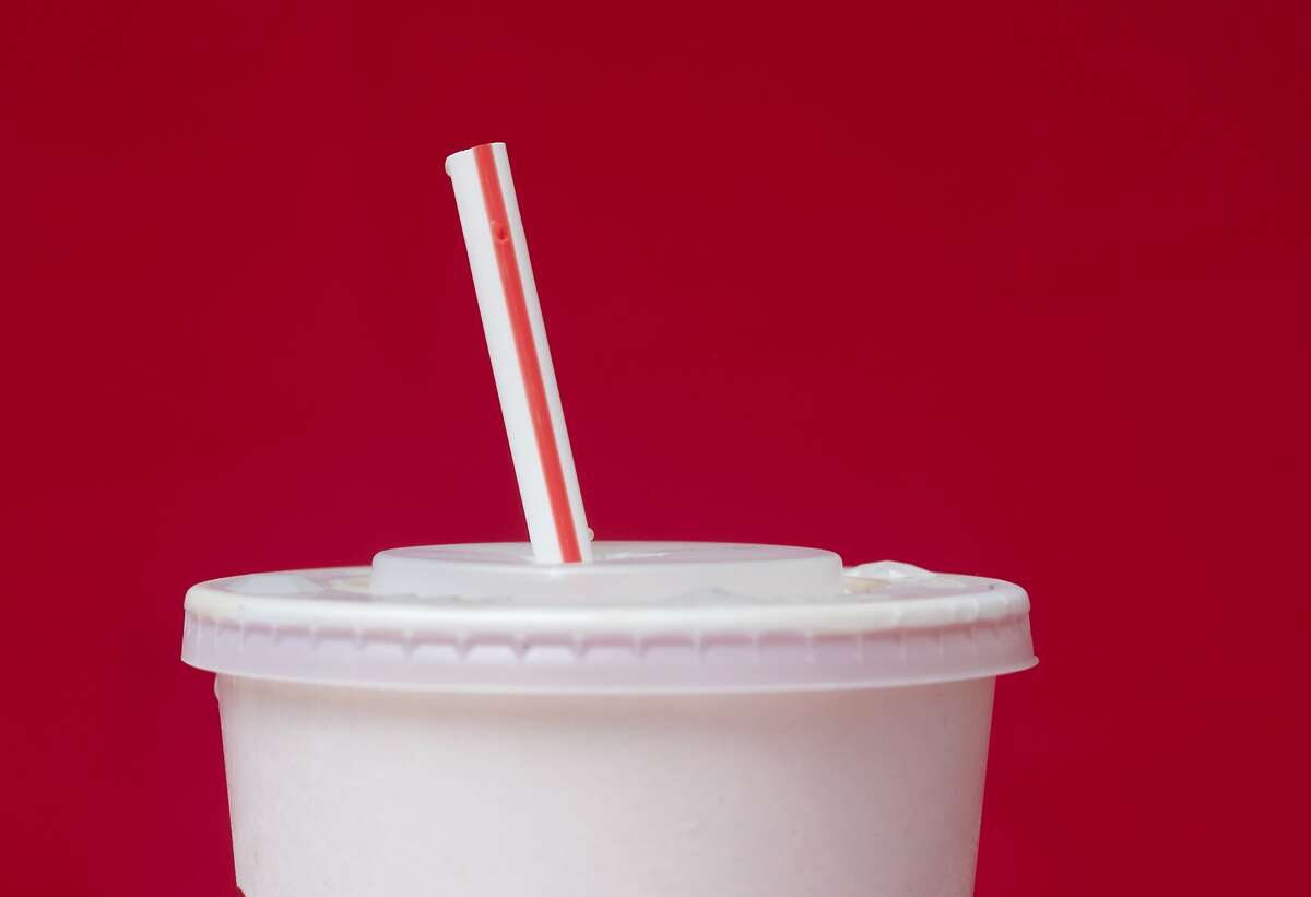 FILE- In this May 24, 2018, file photo, a large soft drink with a plastic straw from a McDonald's restaurant is shown in Surfside, Fla. McDonald's said Friday, June 15, that it will switch to paper straws at all its locations in the United Kingdom and Ireland, and test an alternative to plastic ones in some of its U.S. restaurants later this year. (AP Photo/Wilfredo Lee, File)