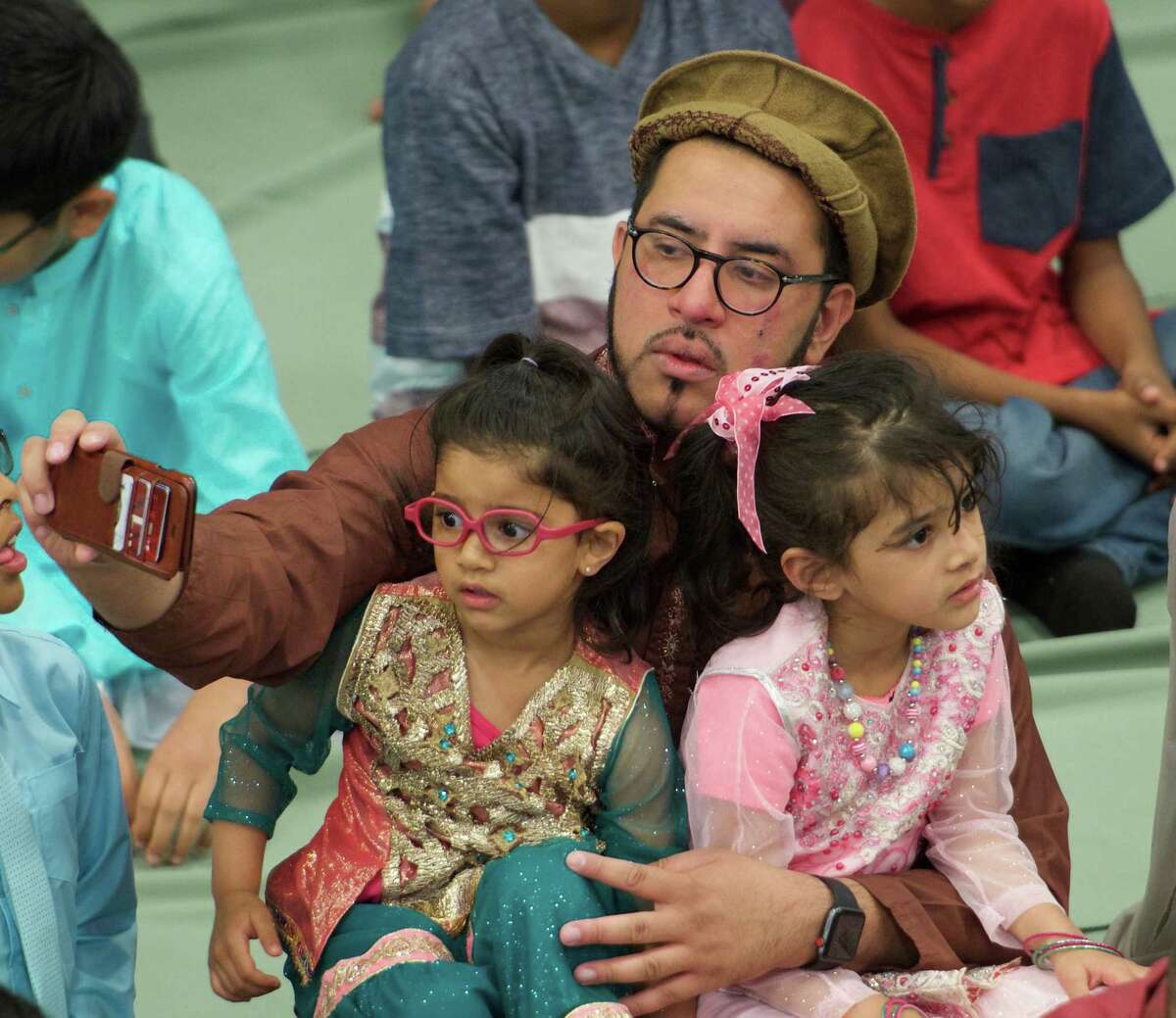 A young member of the congregation gets a selfie with a relative before the start of the Eid Al-Fitr ceremony at the Muslim Community Center Friday June 15, 2018 in Colonie, N.Y. (Skip Dickstein/Times Union)