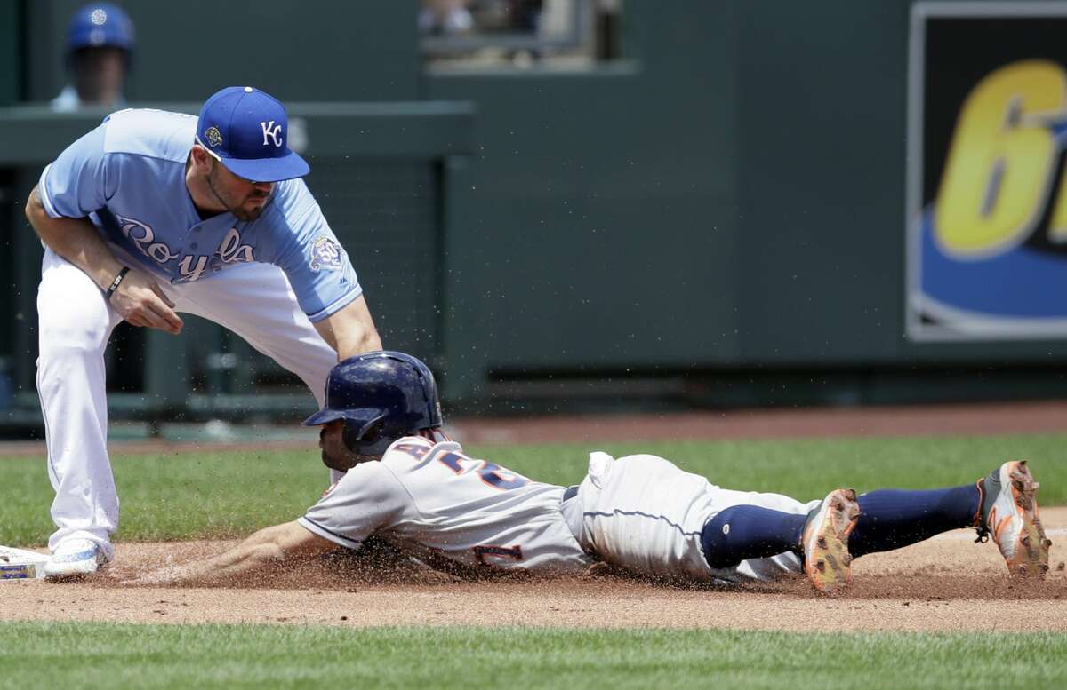 Houston Astros' Jose Altuve (27) is tagged out while trying to advance on a sacrifice fly by Kansas City Royals third baseman Mike Moustakas (8) during the first inning of a baseball game at Kauffman Stadium in Kansas City, Mo., Saturday, June 16, 2018. (AP Photo/Orlin Wagner)
