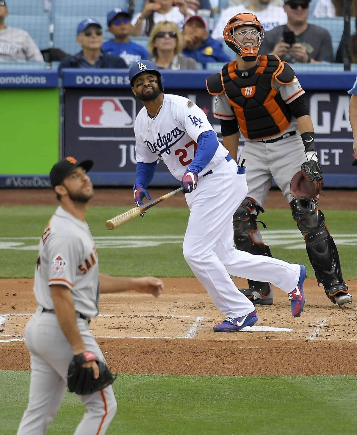 Los Angeles Dodgers' Matt Kemp, center, hits a solo home run as San Francisco Giants starting pitcher Madison Bumgarner, left, watches along with catcher Buster Posey during the second inning of a baseball game Saturday, June 16, 2018, in Los Angeles. 