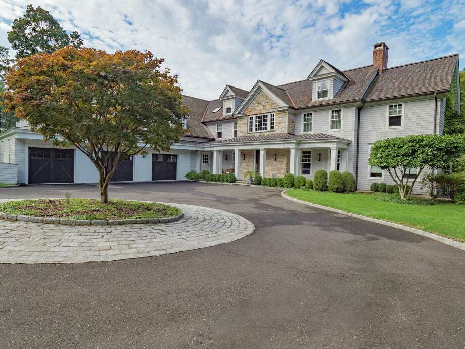 The gray colonial house at 6 Cob Drive contains 15 room and 7,700 square feet of living space with elegant formal spaces and comfortable places to relax inside an out. Photo: PAUL WEAR / PAUL WEAR