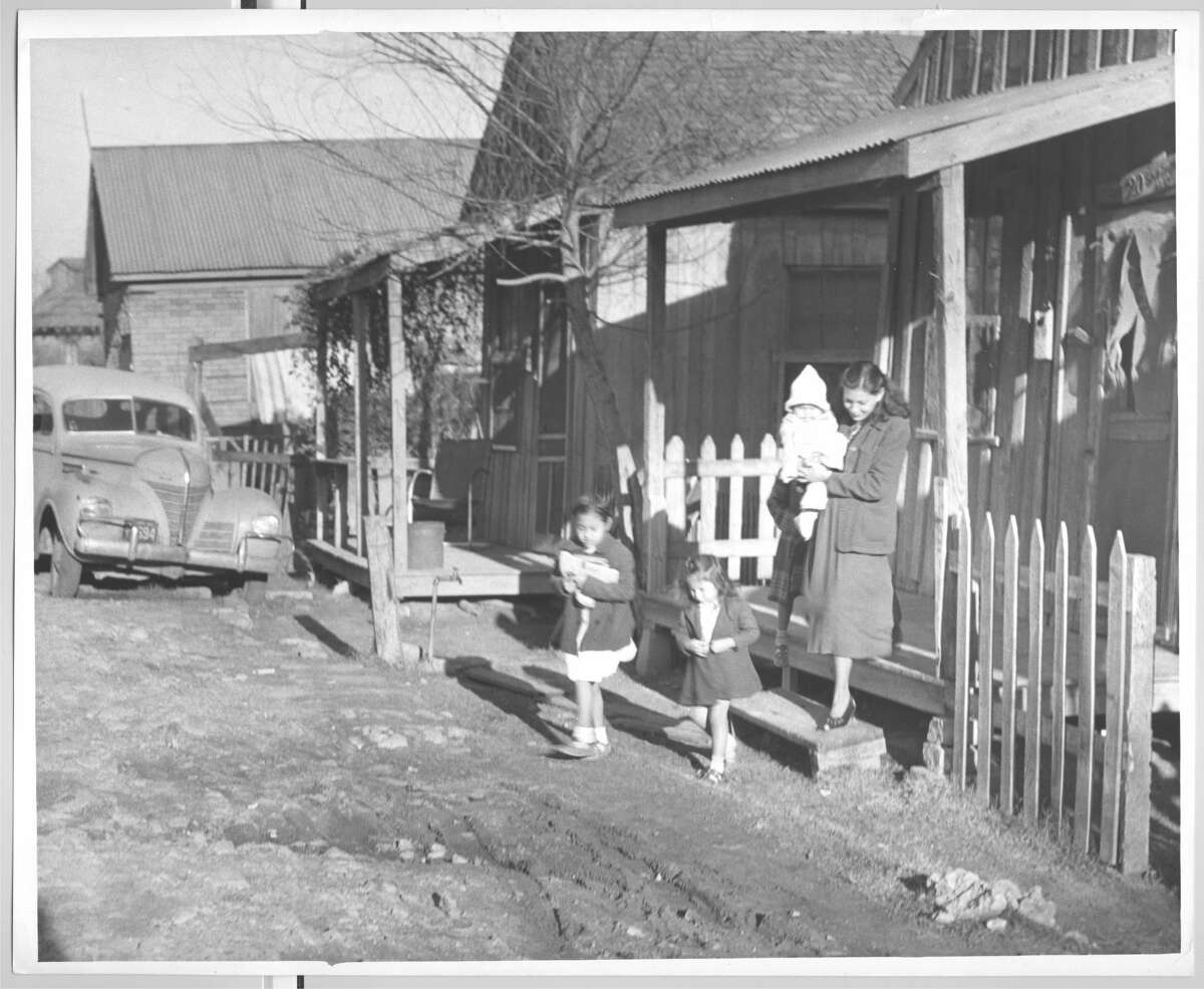 January 1950: A family in Schrimpf Alley, a neighborhood outside of downtown, near Navigation and Jensen Drive.