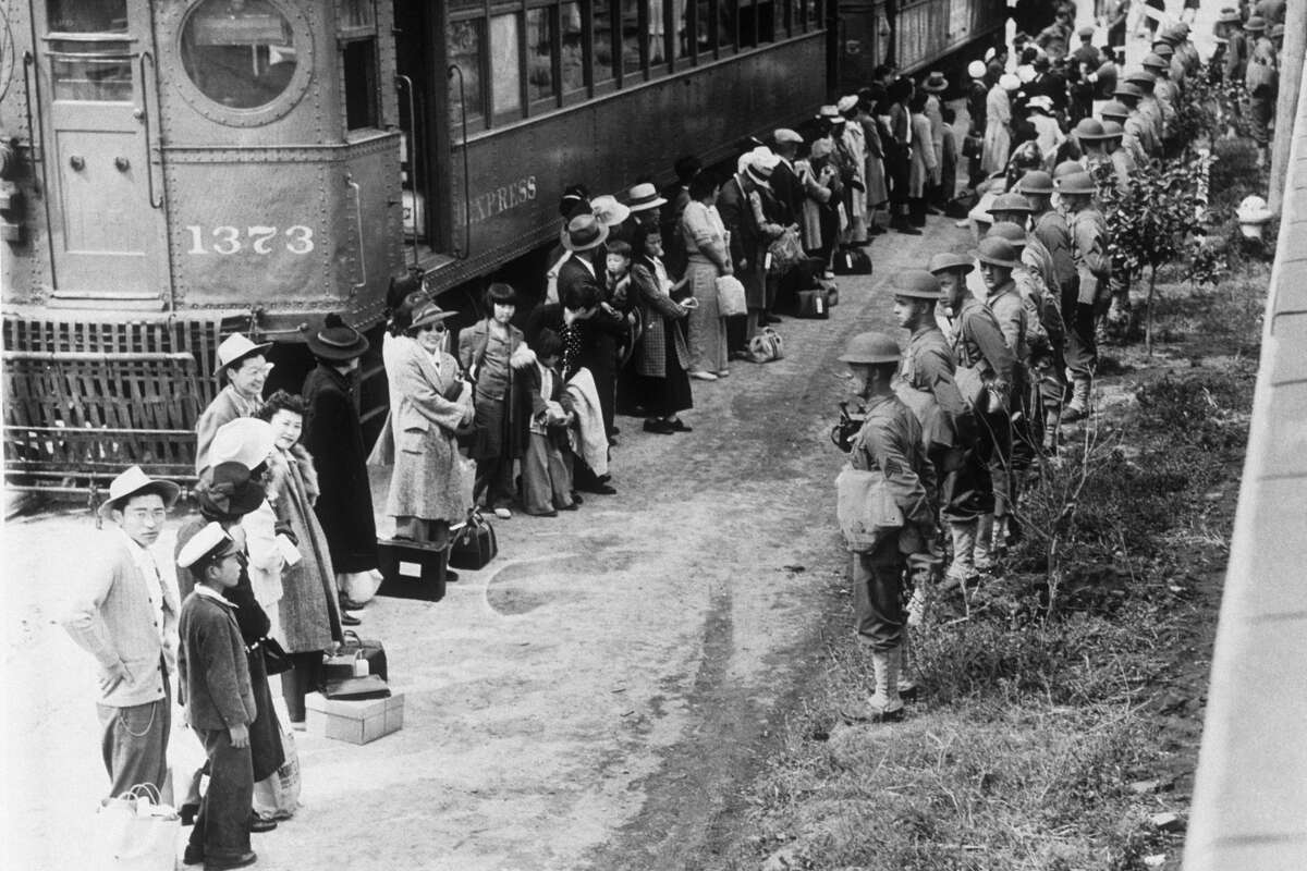 American troops supervise the movement of Japanese Americans from their homes on the American west coast to ten specially built camps after Japanese's attack on Pearl Harbour during World War II.