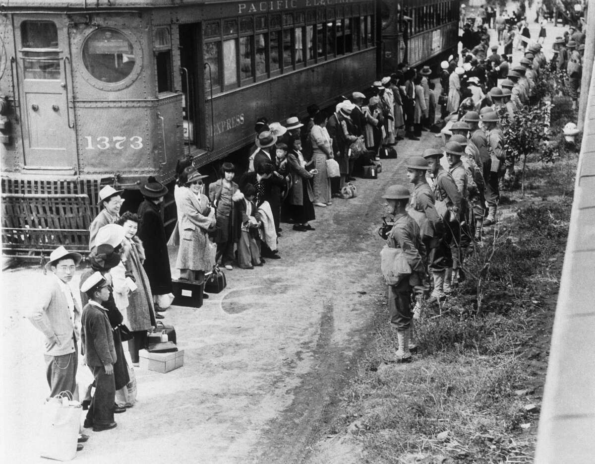 American troops supervise the movement of Japanese Americans from their homes on the American west coast to ten specially built camps after Japanese's attack on Pearl Harbour during World War II.