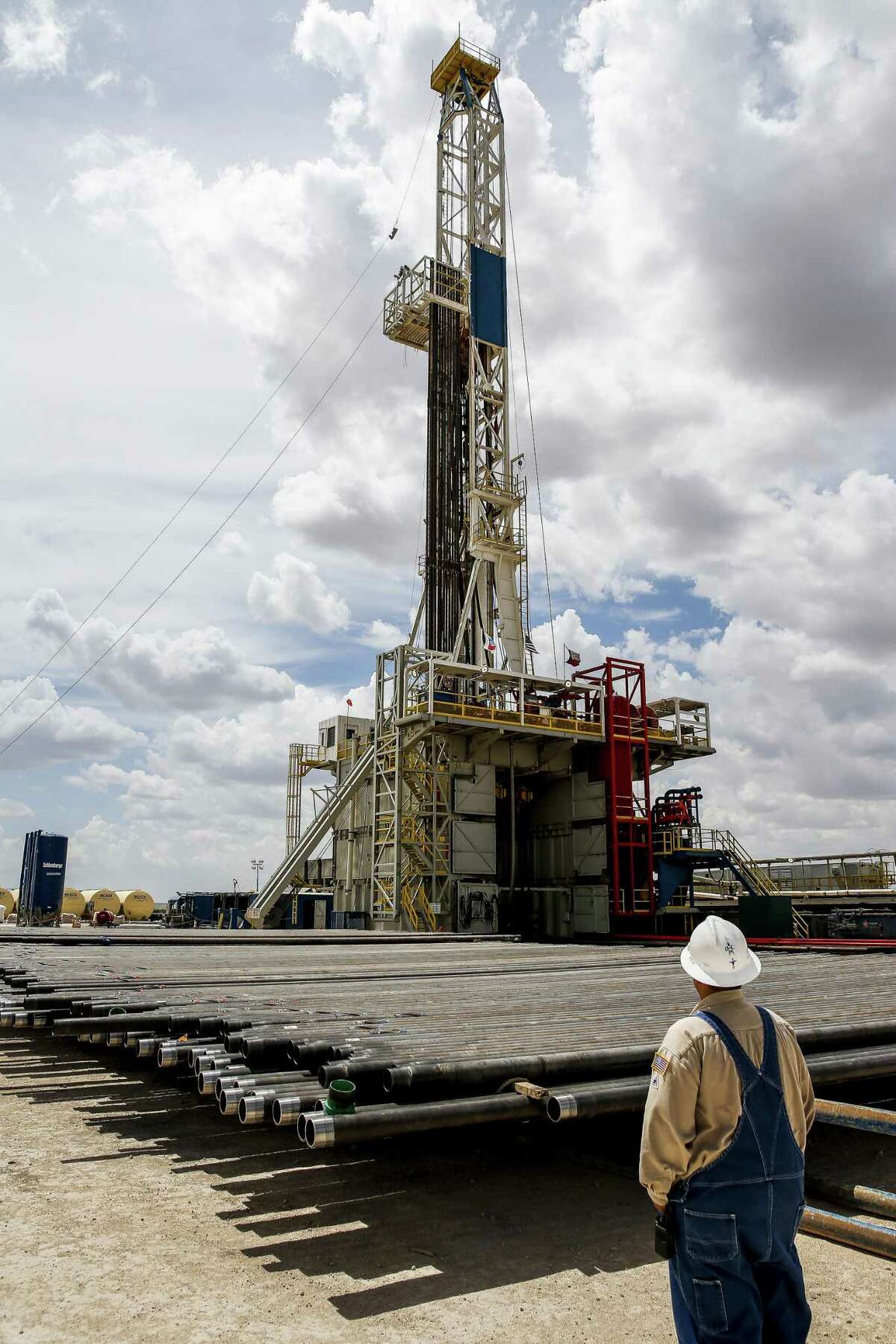 A drill rig sits on a pad site where it will drill three to six wells next to each other at a Chevron drilling site Wednesday, July 19, 2017 in Midland. Oil majors led by Exxon Mobil and Chevron will need to bulk up their Permian Basin spending to meet their growth goals, triggering more consolidation and higher costs for oilfield services, according to a new report.