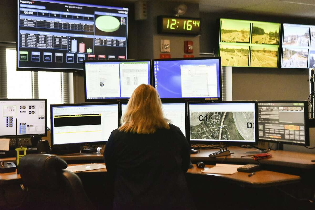 FILE - In this March 15, 2018, file photo, a dispatcher works at a desk station with a variety of screens used by those who take 911 emergency calls in Roswell, Ga. Apple is trying drag the U.S.�s antiquated system for handling 911 calls into the 21st century. If it lives up to Apple�s promise, the iPhone�s next operating system will automatically deliver quicker and more reliable information pinpointing the location of 911 calls to about 6,300 emergency response centers in the U.S. (AP Photo/Lisa Marie Pane, File)
