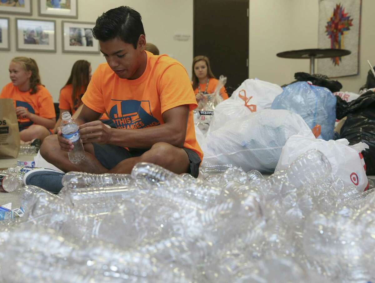 Living Word Lutheran Church High School Youth Group memer Ismael Castillo peels a label off of a plastic water bottle for an art installation project for a part of the upcoming Evangelical Lutheran Church in America's (ELCA) ELCA Youth Gathering on Friday, June 15, 2018, in Katy. The church collected over 2,000 plastic bottles from a drive in the span of roughly a month. More than 30,000 youth, adult leaders and others from the ELCA from all over the nation will participate in the ELCA Youth Gathering in Houston June 25-July 1. ( Yi-Chin Lee / Houston Chronicle )