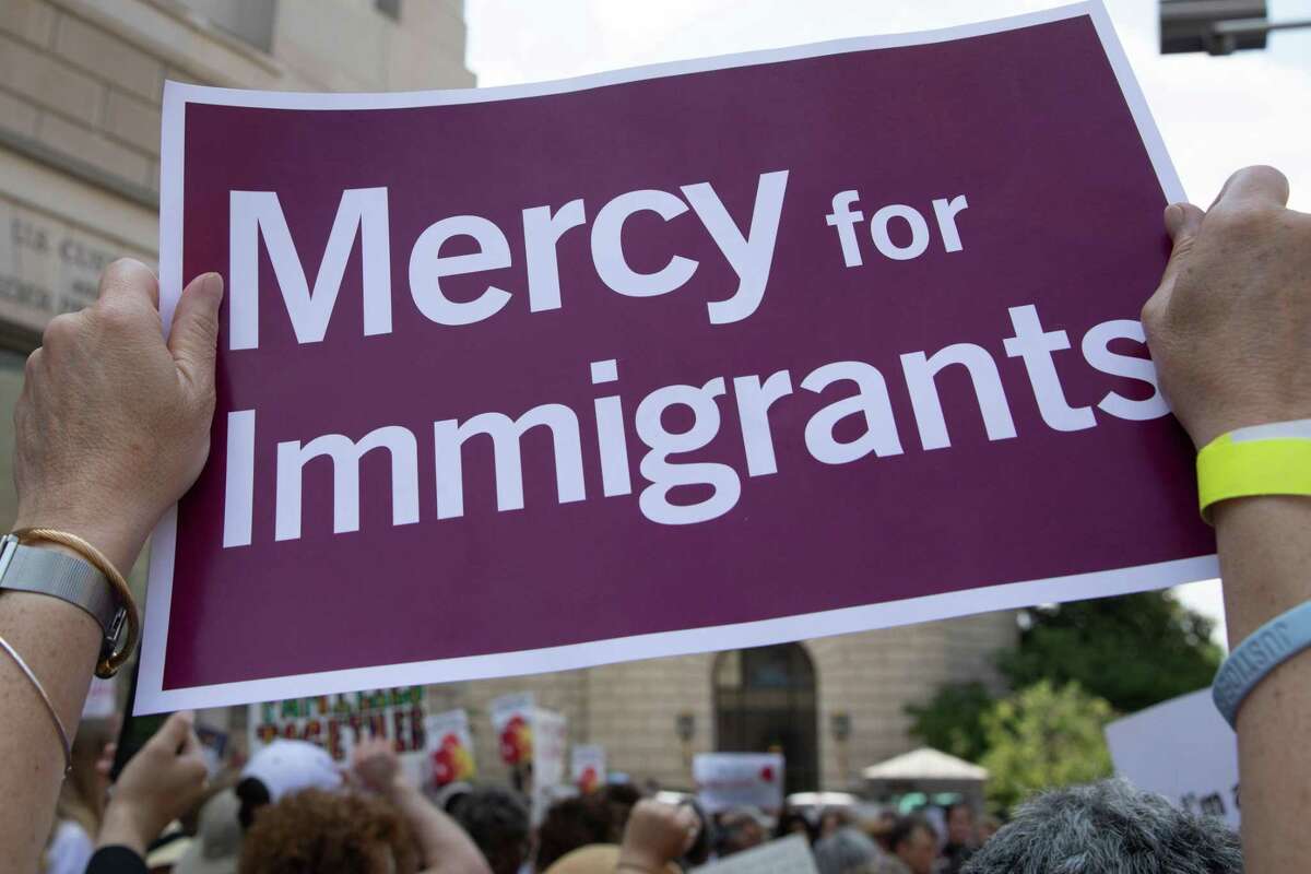A demonstrator holds a protest sign during a rally against the separation of immigrant minors and their parents outside the Customers and Border Protection headquarters in Washington. Online donors have responded to call to assist immigrants separated from children in effort that helps S.A.-based legal nonprofit group RAICES.