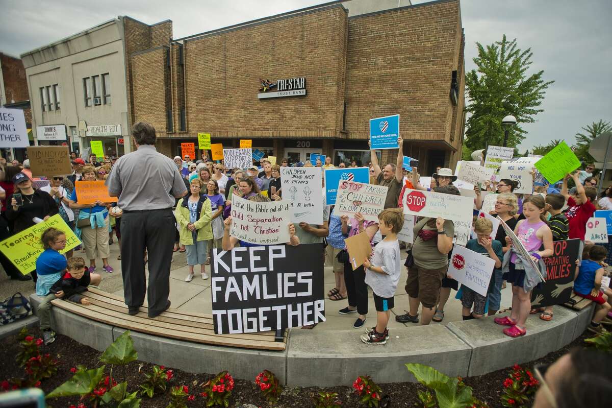More than 100 people gather to protest the Trump administration's decision to separate immigrant families at the border on Tuesday, June 19, 2018 in downtown Midland. After speakers addressed the crowd at the corner of Main and McDonald, the crowd marched down Main Street to the Midland County Courthouse, where a rededication ceremony was underway for the courthouse's new entryway. (Katy Kildee/kkildee@mdn.net)