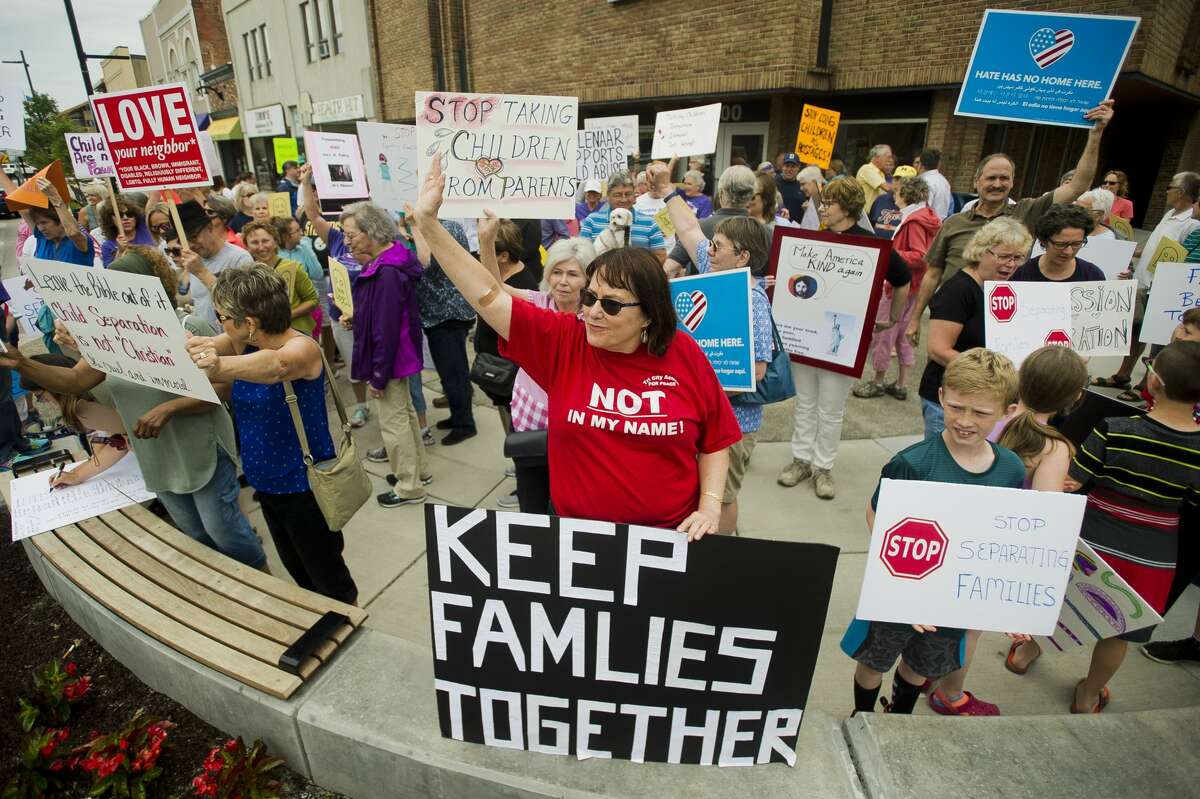 More than 100 people gather to protest the Trump administration's decision to separate immigrant families at the border on Tuesday, June 19, 2018 in downtown Midland. After speakers addressed the crowd at the corner of Main and McDonald, the crowd marched down Main Street to the Midland County Courthouse, where a rededication ceremony was underway for the courthouse's new entryway. (Katy Kildee/kkildee@mdn.net)