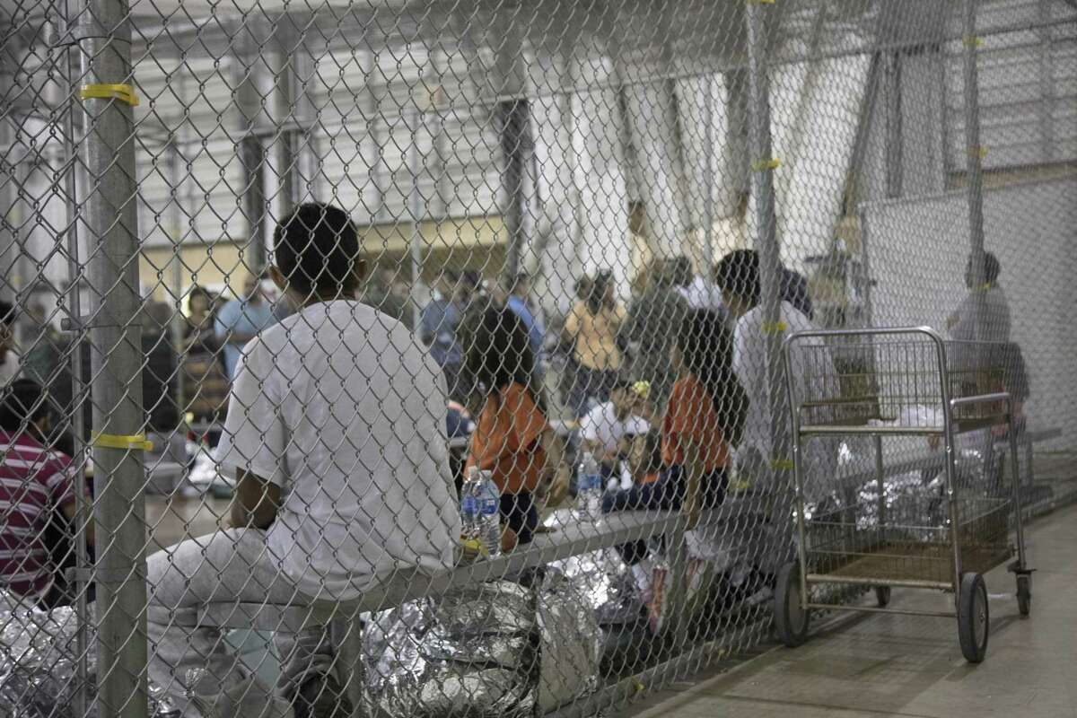 In this photo provided by U.S. Customs and Border Protection, people who've been taken into custody related to cases of illegal entry into the United States, sit in one of the cages at a facility in McAllen, Texas, Sunday, June 17, 2018.