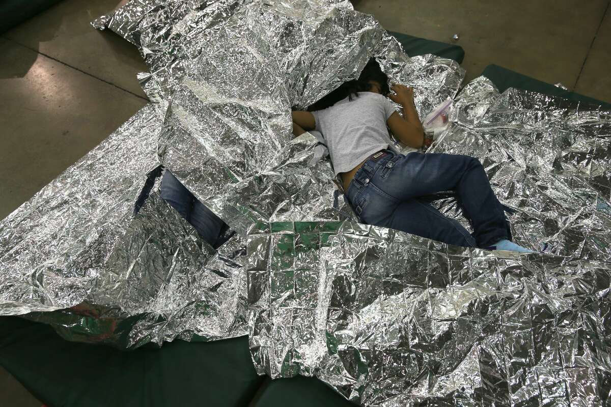 MCALLEN, TX - SEPTEMBER 08: A girl from Central America rests on thermal blankets at a detention facility run by the U.S. Border Patrol on September 8, 2014 in McAllen, Texas. The Border Patrol opened the holding center to temporarily house the children after tens of thousands of families and unaccompanied minors from Central America crossed the border illegally into the United States during the spring and summer. Although the flow of underage immigrants has since slowed greatly, thousands of them are now housed in centers around the United States as immigration courts process their cases. (Photo by John Moore/Getty Images)