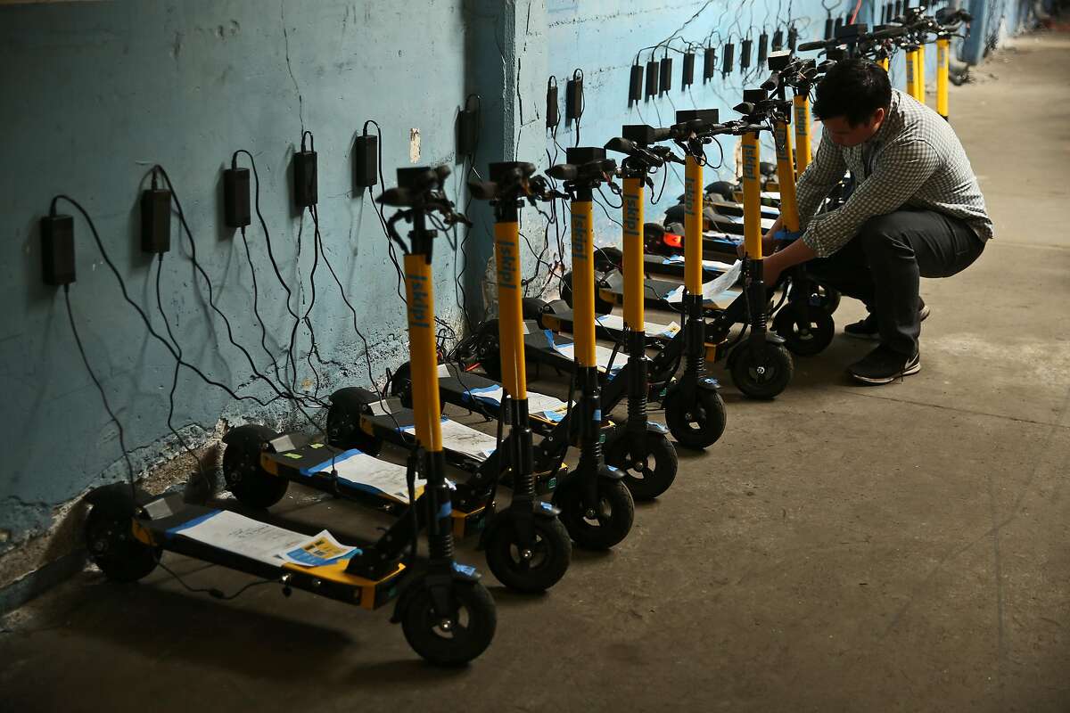 Skip cofounder Matthew Tran checks his scooters, Friday, June 15, 2018, in San Francisco, Calif. Skip, a scooter rental, is one of 12 companies applying for a permit to have an e-scooter program in the city.