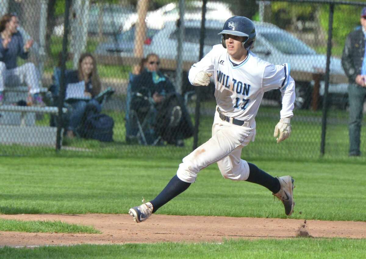 Wilton High School’s #17 Henry Strmecki rounds third base to score a run during baseball action vs Greenwich High on Monday May 8, 2017 in Wilton Conn.