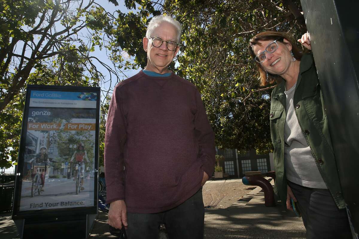 Helen Goldsmith (right) started noticing a time capsule on this corner sidewalk next to 1500 Sansome Street three years ago while taking neighborhood walks with her husband Paul Heller (left) on Wednesday, June 13, 2018 in San Francisco, Calif.