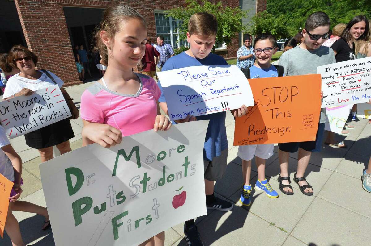 West Rocks Middle School 8th grader Autumn Anderson holds a sign as she stands with other students in support of their Principal Dr. Lynne Moore in front of City Hall on Tuesday June 19, 2018 in Norwalk Conn. More than one hundred people rallied and praised Moore in response to talks about removing her from West Rocks school