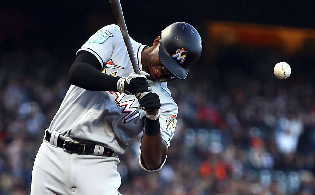 Miami Marlins' Lewis Brinson is hit by a pitch thrown by San Francisco Giants' Dereck Rodriguez during the second inning of a baseball game Tuesday, June 19, 2018, in San Francisco. (AP Photo/Ben Margot)