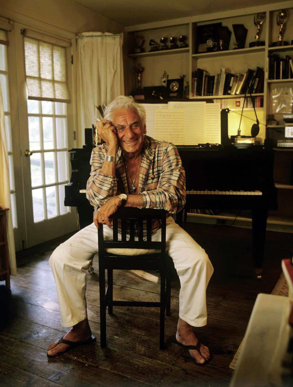 FAIRFIELD, CT - 1986: Composer Leonard Bernstein poses near a piano in 1986 at Springate, his Fairfield, Connecticut home. Bernstein's most recognizable affiliation was as the longtime music director of the New York Philharmonic Orchestra. In addition, Bernstein was noted for writing the music for the highly acclaimed musical, West Side Story. (Photo by Joe McNally/Getty Images)