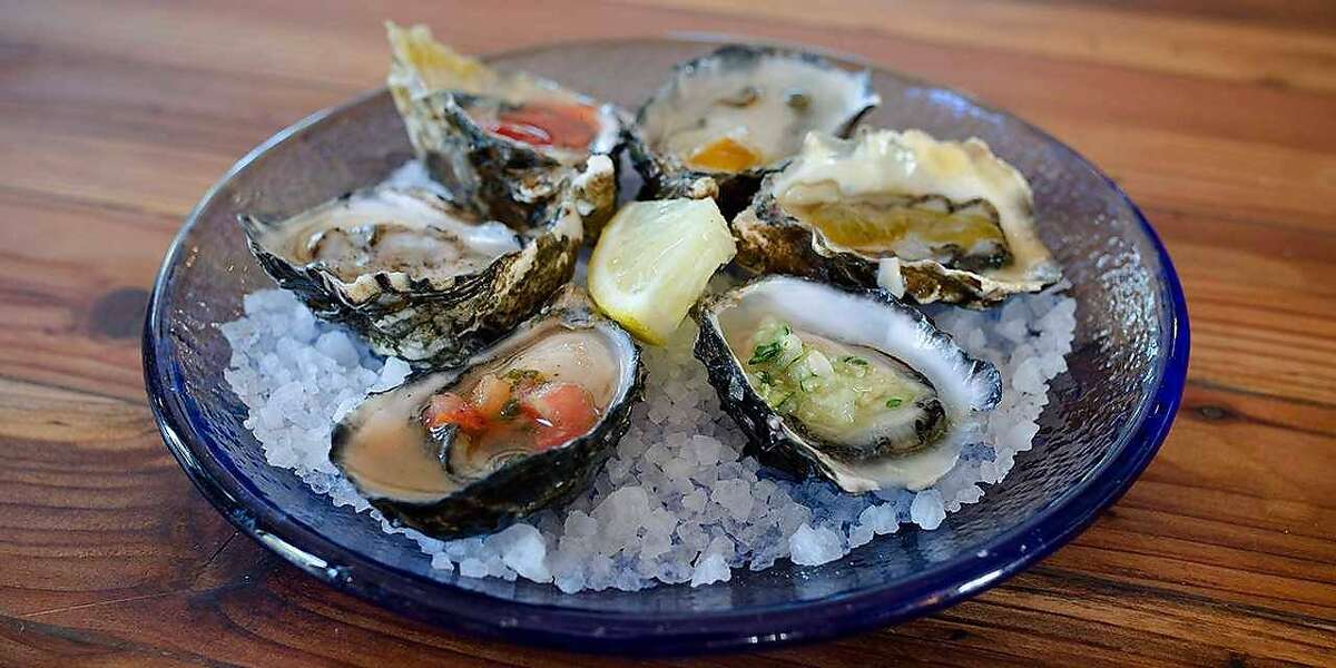 The First Mate Platter at Humboldt Bay Provisions features six raw bucksport oysters dressed with sauces.