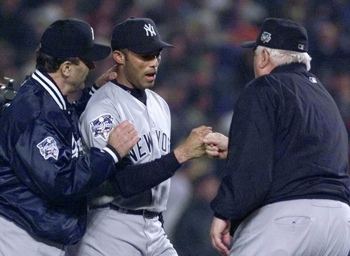 New York Yankees relief pitcher Mariano Rivera, center, is congratulated by manager Joe Torre, left, and acting pitching coach Billy Connors after beating the New York Mets 3-2 in Game 4 of the World Series Wednesday Oct. 25, 2000, at Shea Stadium in New York. Rivera earned the save.