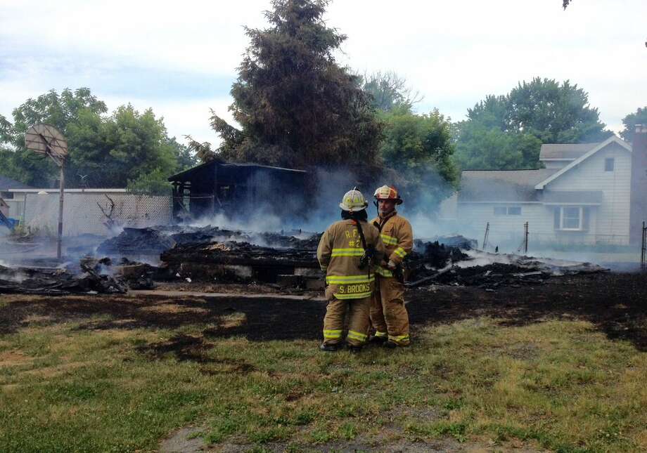 Firefighters stand amid the rubble of a house fire at 1049 Laura Street in Rotterdam on June 20, 2018. Photo: John Carl D'Annibale