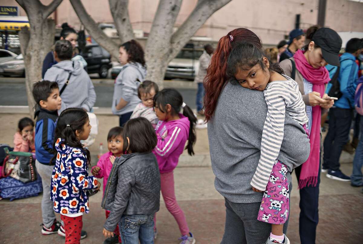 Undocumented migrants wait for asylum hearings outside the port of entry in Tijuana, Mexico, June 20, 2018. President Donald Trump caved to enormous political pressure on Wednesday and signed an executive order that ends the separation of families by indefinitely detaining parents and children together at the border. 