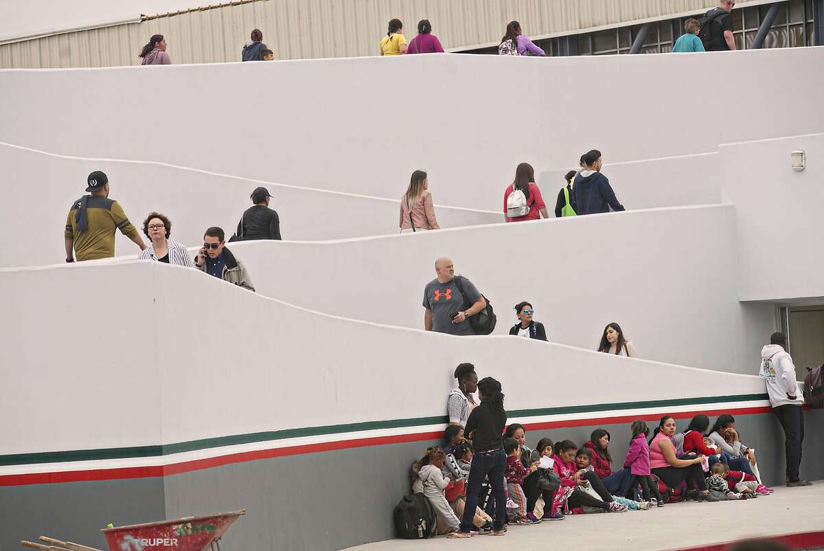 Undocumented migrants wait for asylum hearings outside the port of entry in Tijuana, Mexico, June 20, 2018. President Donald Trump caved to enormous political pressure on Wednesday and signed an executive order that ends the separation of families by indefinitely detaining parents and children together at the border. 