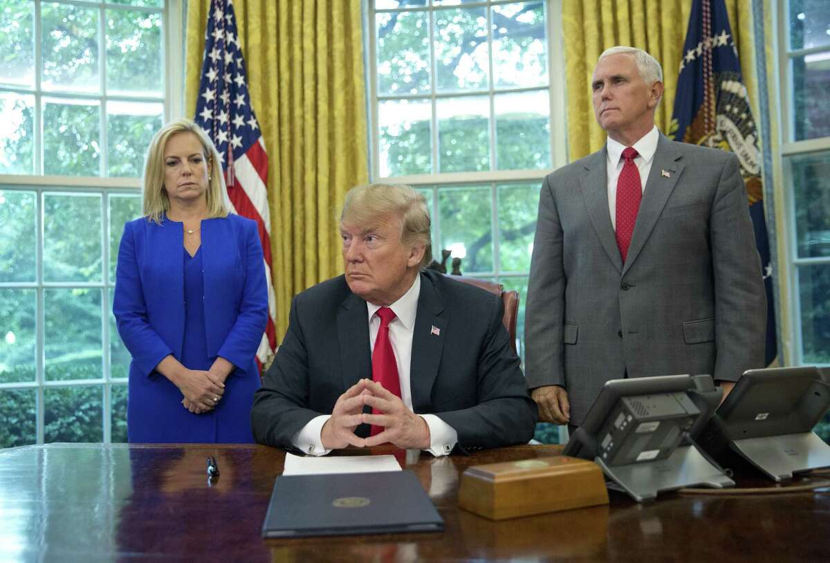 President Trump, center, with Homeland Security Secretary Kirstjen Nielsen, left, and Vice President Mike Pence, before signing an executive order to end family separations, during an event in the Oval Office Wednesday, June 20, 2018.
