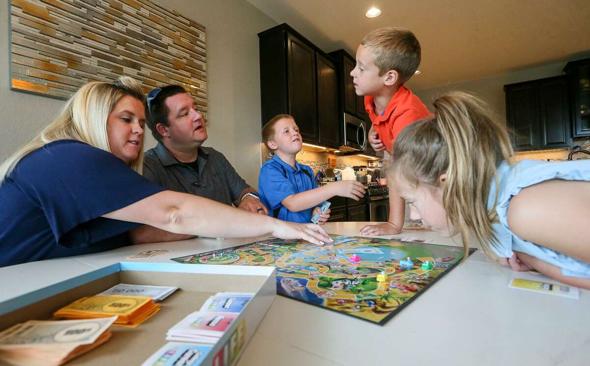 The Nolan family — Jennifer (from left), Kelly, Collin, 8, Lane, 5, and Kenzi, 8 — play a board game of Life at their home in the Sablechase subdivision in the Fair Oaks Ranch area. The family moved to Bexar County from the St. Louis area in August 2017 for Kelly Nolan’s job.