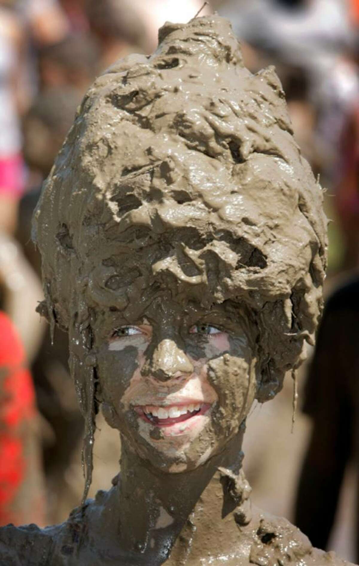 WESTLAND, MI - JULY 6: Logan Sibel, age 12, of Redford, Michigan gets some relief from the heat by playing in a gigantic lake of mud at the annual Mud Day event July 6, 2010 in Westland, Michigan. The lake was created by mixing approximately 20,000 gallons of water with 200 tons of topsoil. The event, which is sponsored by the Wayne County Parks Department, draws about 1,000 children each year. (Photo by Bill Pugliano/Getty Images) *** Local Caption *** Logan Sibel