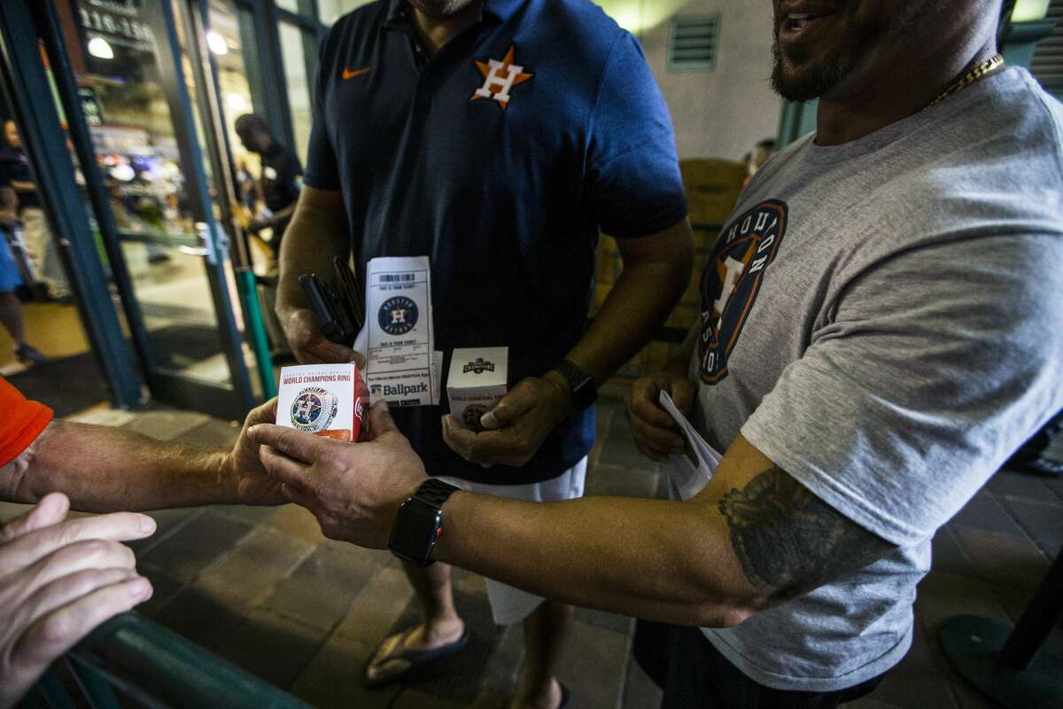 Mark Stulberger helps hand out replica World Series rings to ticketed fans before the Houston Astros major league baseball game against the Tampa Bay Rays at Minute Maid Park on Wednesday, June 20, 2018, in Houston. ( Brett Coomer / Houston Chronicle )