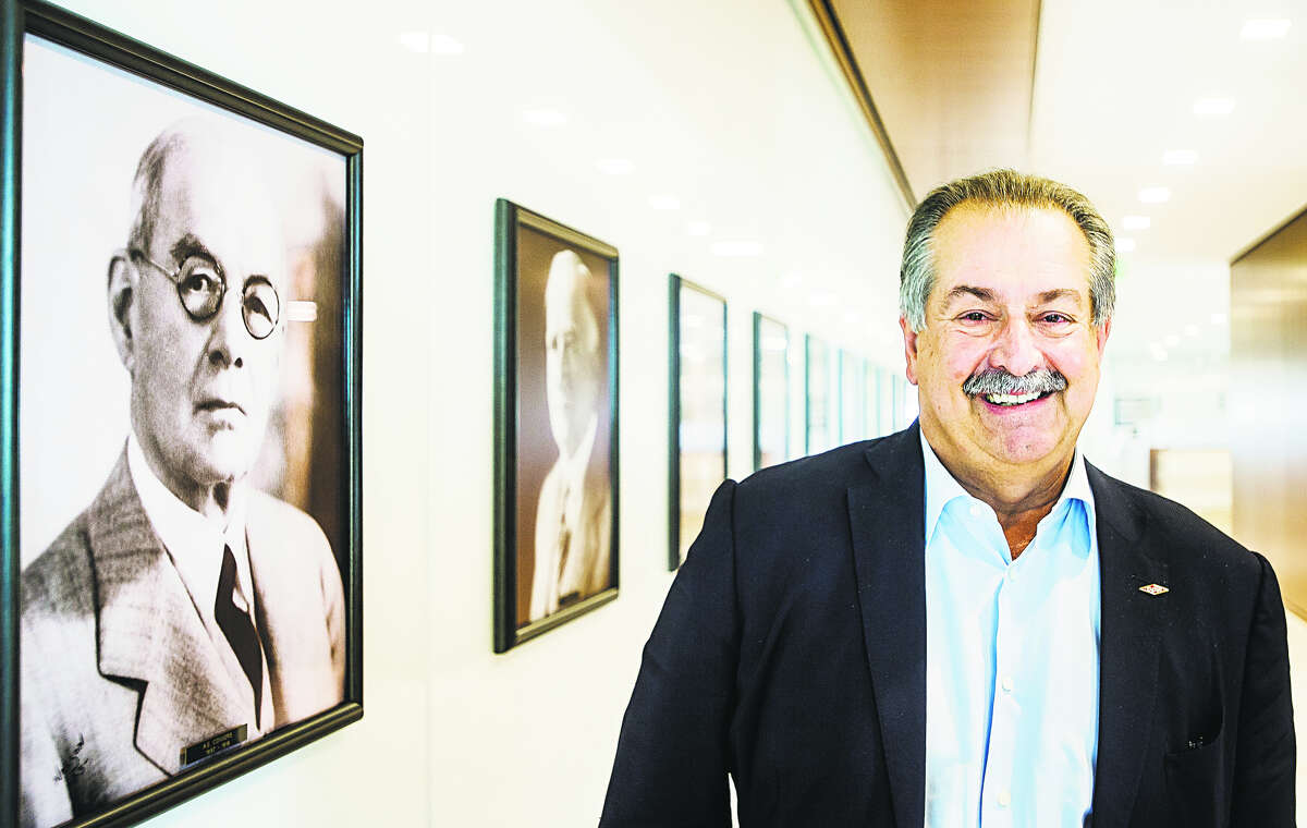 Dow CEO Andrew Liveris poses for a portrait last week alongside photographs of A. E. Convers, left, and Herbert Henry Dow, second from left, at Dow’s corporate Midland campus. (Katy Kildee/kkildee@mdn.net)