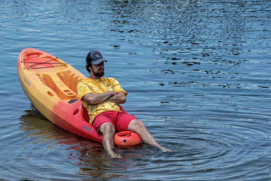 Jonah Stalled, 25 of Saratoga waits for his next kayak rental at the Kayak Shack by dunking his feet in Fish Creek at the north end of Saratoga Lake Thursday June 21, 2018 on the first day of summer in Saratoga Springs, N.Y. (Skip Dickstein/Times Union) Photo: SKIP DICKSTEIN, Albany Times Union