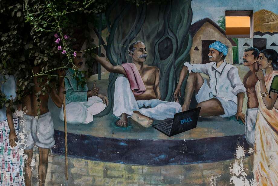 Mural picturing traditional indian villagers using a laptop painted on the fence of an engineering company in HITEC City in Hyderabad. HITEC city stands for Hyderabad Information Technology and Engineering Consultancy City. Photo: Bernat Parera / Special To The Chronicle 2016