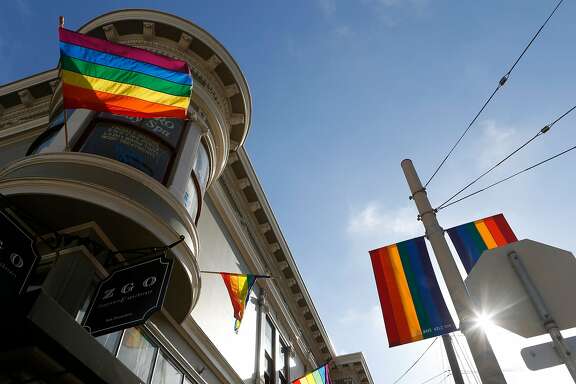The sun peaks through Pride flags on the corner of 19th and Castro Streets on Tuesday, June 19, 2018 in San Francisco, Calif.