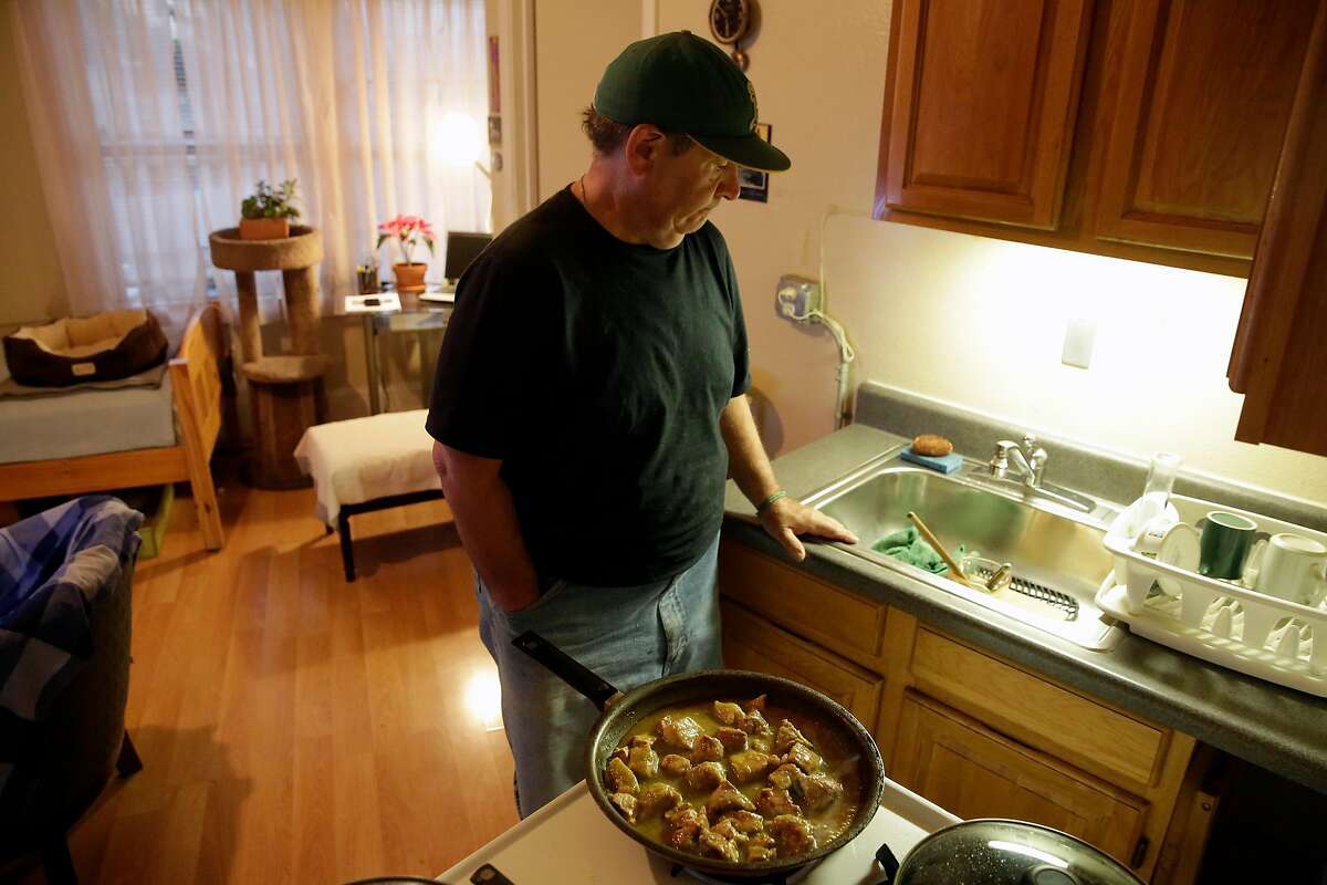 Steve Summers fixes his evening meal in his apartment in Oakland, Calif., seen on Tuesday Feb. 13, 2018. Summers relies on the benefits of the Federal governments Supplemental Nutritional Assistance Program, (food stamps) to buy fresh pork to make salsa verde as well as items from a local food pantry.