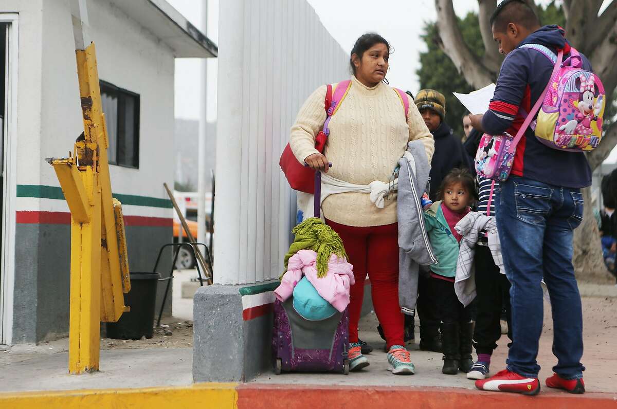 TIJUANA, MEXICO - JUNE 21: A migrant mother waits with her two daughters on their way to the port of entry to ask for asylum in the U.S. on June 21, 2018 in Tijuana, Mexico. The mother, who did not wish to give their names, said they were fleeing their hometown near the Pacific coast of Mexico after suffering a violent carjacking of her taxicab. The Trump Administration's controversial zero tolerance immigration policy led to an increase in the number of migrant children who have been separated from their families at the southern U.S. border. U.S. Attorney General Jeff Sessions has added that domestic and gang violence in immigrants' country of origin would no longer qualify them for political asylum status. (Photo by Mario Tama/Getty Images)