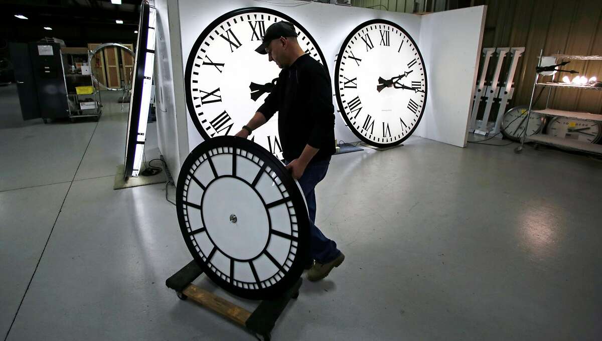 Dan LaMoore wheels a clock away from the test area as it is prepared to be shipped to a Tennessee school at the Electric Time Company in Medfield, Mass., Thursday, March 10, 2016. Most Americans will lose an hour of sleep this weekend, but gain an hour of evening light for months ahead, as Daylight Saving Time returns this weekend. The time change officially starts Sunday at 2 a.m. local time. (AP Photo/Charles Krupa)