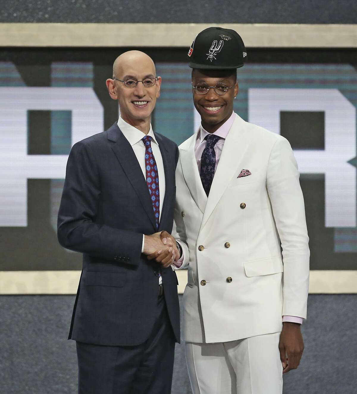 Miami's Lonnie Walker IV, right, poses with NBA Commissioner Adam Silver after he was picked 18th overall by the San Antonio Spurs during the NBA basketball draft in New York, Thursday, June 21, 2018. (AP Photo/Kevin Hagen)