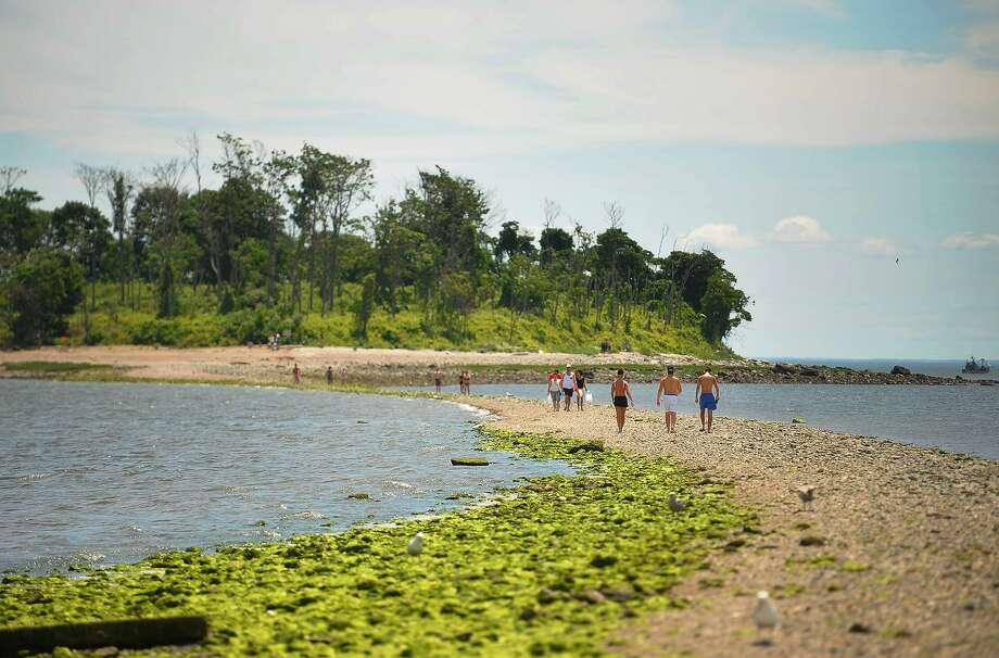 beachgoers walk out on the tombolo to charles