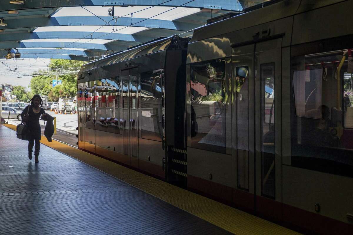 A woman runs for an inbound train at West Portal Station.