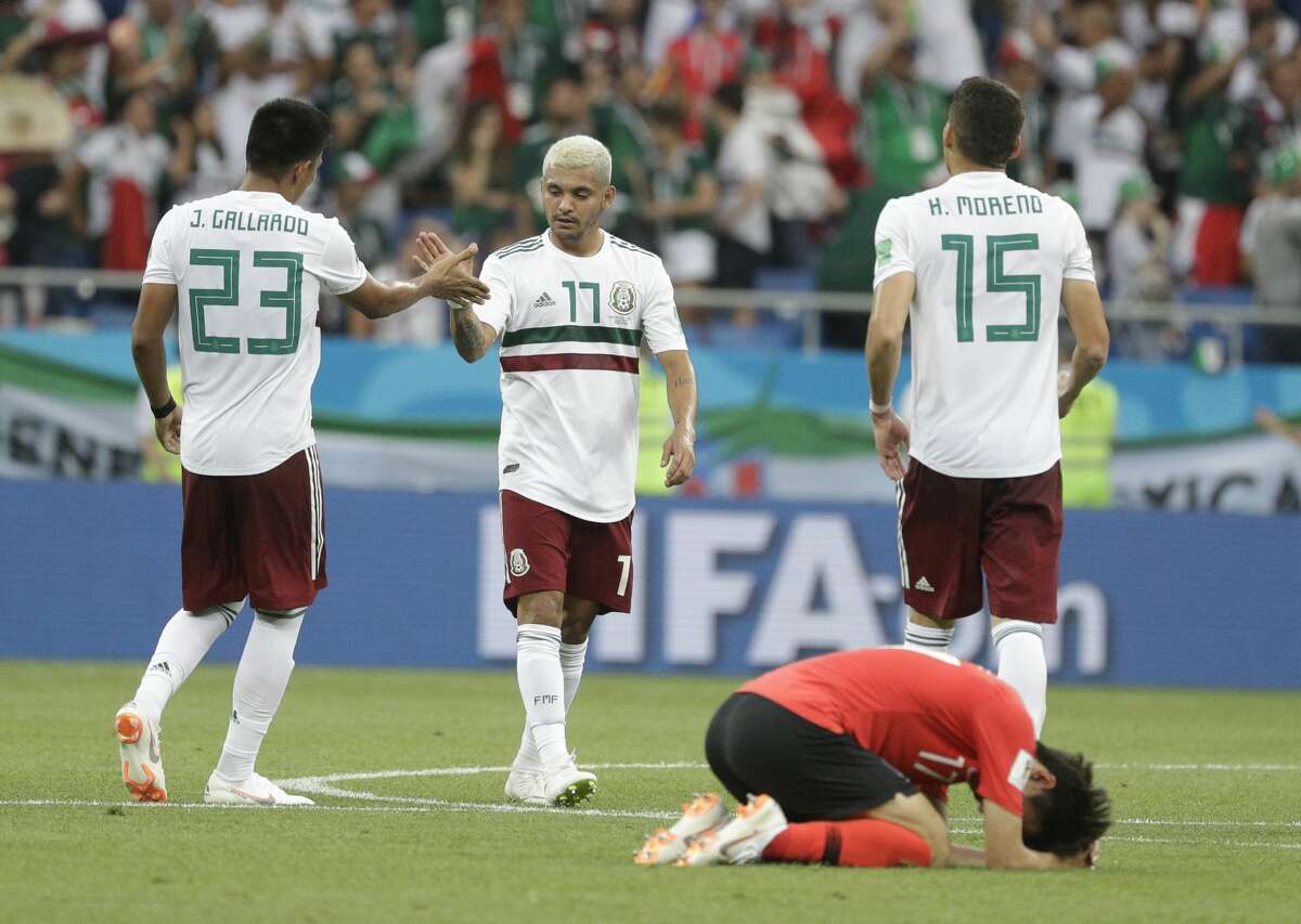 Mexico's Jesus Corona, center, clasps hands with Mexico's Jesus Gallardo as South Korea's Lee Jae-sung lies on the pitch after the group F match between Mexico and South Korea at the 2018 soccer World Cup in the Rostov Arena in Rostov-on-Don, Russia, Saturday, June 23, 2018. (AP Photo/Gregorio Borgia)