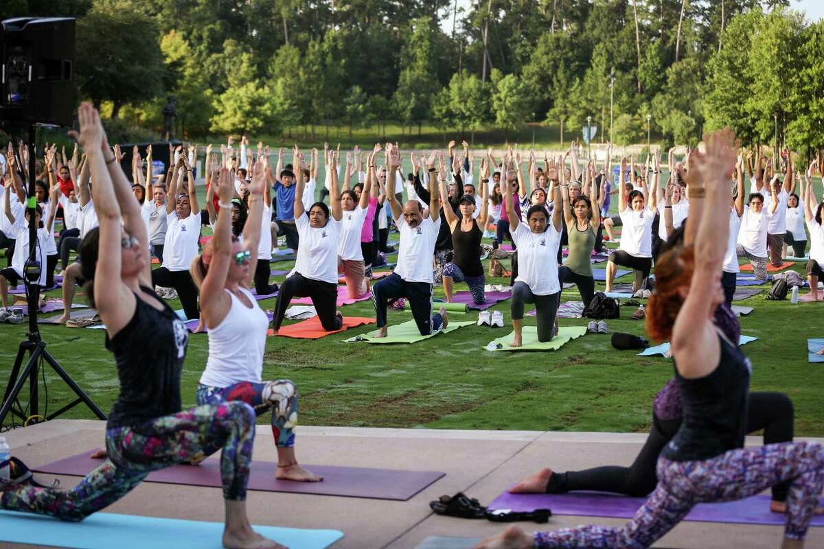 Attendees follow along with a yoga routine during the International Yoga Day celebration, hosted by the Hindu Temple of The Woodlands, on Saturday, June 23, 2018, at Town Green Park.