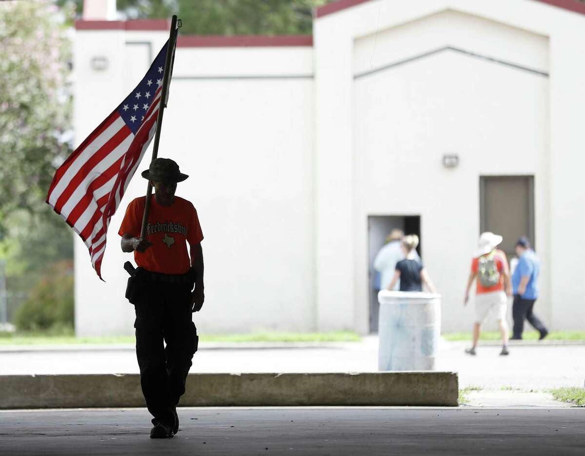 David Treibs, of Fredricksburg, walks with an American flag during a pro-gun rally, at Runge Park Saturday, June 23, 2018, in Santa Fe. This Is Texas Freedom Force (TITFF) invited the public in Santa Fe & surrounding areas to join the discussion about arming teachers and school staff. ( Karen Warren / Houston Chronicle )