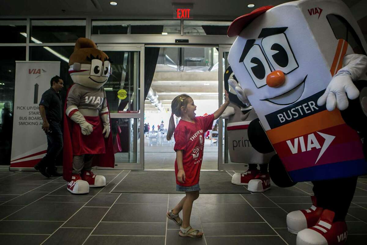 Madeline Everton, 5, high fives Buster, a VIA mascot, at the opening of the new VIA Stone Oak Park and Ride facility along U.S. Highway 281 North June 23, 2018.