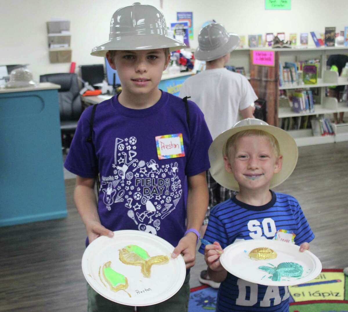 Preston Wiese (left) and Cooper Fulcher (right) show off the painted fossils tthey made at the Shepherd Public Library’s Summer Reading program on June 19.
