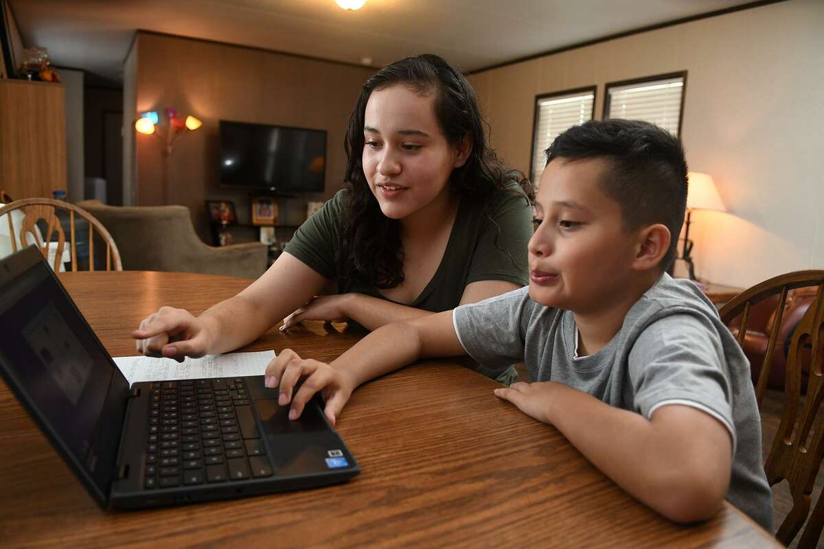 Diana Huerta Cruz, 14, a freshman at Cy Ridge High School, and her brother Oscar, 9, a 4th grader at Kirk Elem., share their student internet access at their home on June 18, 2018. (Jerry Baker/For the Chronicle)