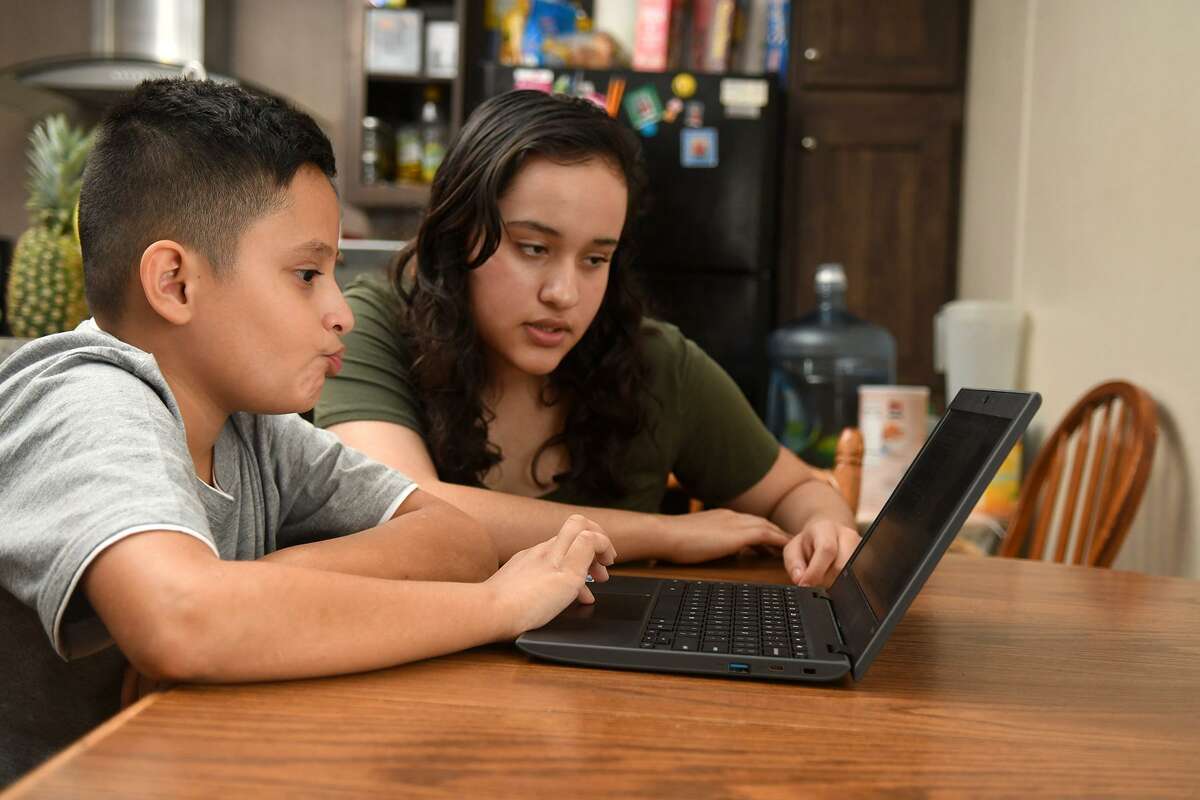 Oscar Cruz, 9, left, a 4th grader at Kirk Elem., and his sister Diana, 14, a freshman at Cy Ridge High School, share their student internet access at their home on June 18, 2018. (Jerry Baker/For the Chronicle)