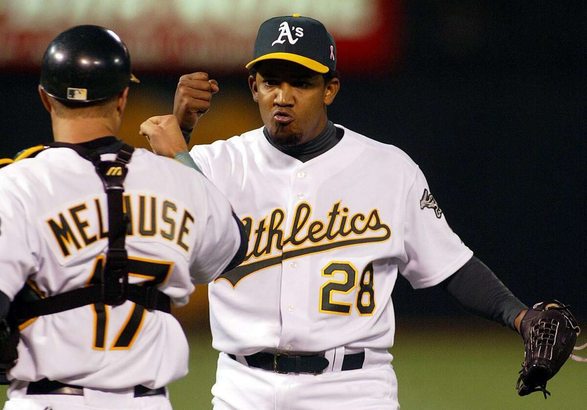 Oakland Athletics pitcher Octavio Dotel, right, is congratulated by catcher Adam Melhuse after getting the final out in the ninth inning against the Cleveland Indians in Oakland, Calif., on Sunday, Sept. 12, 2004. The Athletics won 1-0, Dotel earned his 20th save. (AP Photo/Jeff Chiu) Ran on: 09-13-2004 Octavio Dotel is congratulated by Adam Melhuse following Dotels 34th save, and 20th as an Athletic.